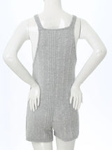 Back view of a sleeveless ribbed maternity jumpsuit in gray, showcasing the loose fit and comfortable fabric.