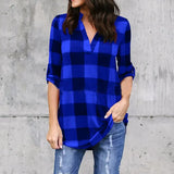 Woman wearing a blue plaid V-neck summer shirt, styled for casual beach outings, paired with distressed jeans.