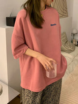 Oversized pink Harajuku streetwear tee with 'Newtr' print, paired with patterned pants, perfect for casual style.