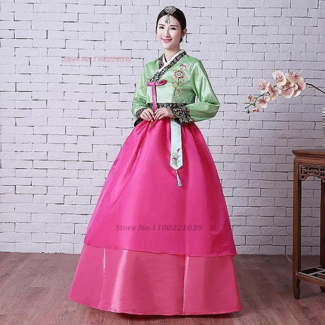 2025 Korean Hanbok Dress featuring floral design, vibrant pink skirt, and traditional green top, perfect for women.