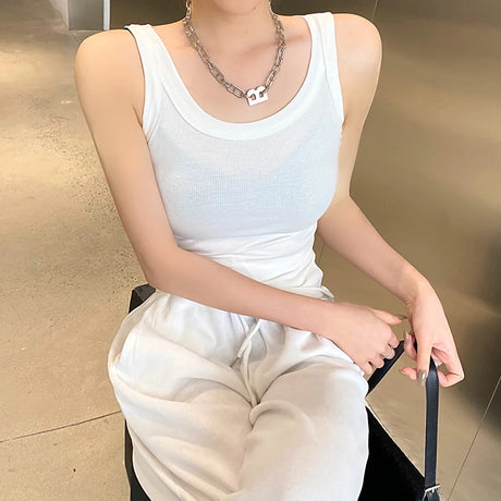 Model wearing a white RetroRib™ 90s vintage ribbed tank top, showcasing a casual streetwear look.