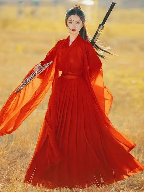 Swordsman Hanfu costume in wine red fabric, featuring flowing sleeves and elegant design in a natural setting.