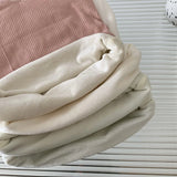 Folded casual velvet crop tank in cream and blush colors, showcasing sleek and comfortable fabric texture.