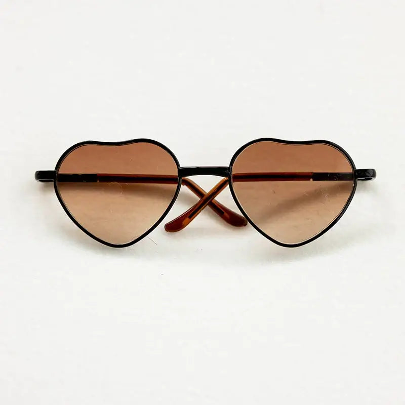 Heart-shaped baby sunglasses for newborn photography, perfect colorful accessory for gender-neutral photo shoots.