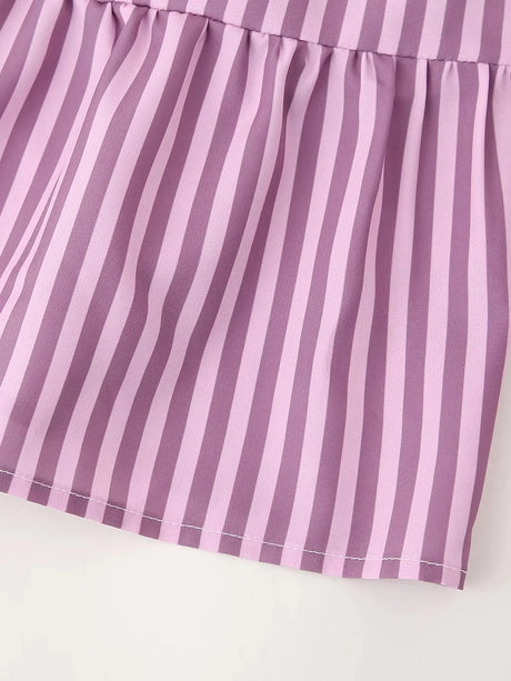 Close-up of the BowChic™ stripe lace-up blouse in soft lavender color with elegant pleated bottom.