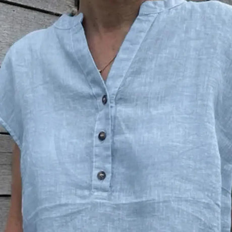Close-up of a light blue cotton linen V-neck blouse featuring button closure and casual style, perfect for summer.