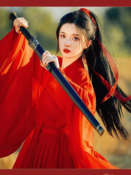 Woman in a red Hanfu costume holding a sword, embodying Tang Dynasty elegance and style.