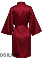 Back view of a burgundy satin robe with kimono sleeves and a tie belt, perfect for bridesmaids or lounging.