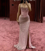 Elegant pink mermaid wedding dress featuring crystal bead embellishments and a high slit for a stunning look.