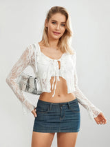 Model wearing TieGlam™ sheer lace crop cardigan with flare sleeves and front tie, paired with a denim skirt.