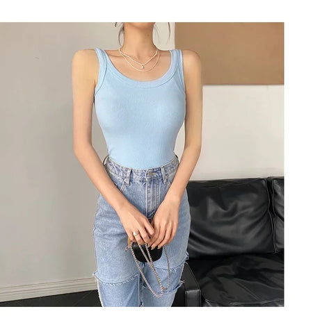 Light blue ribbed tank top worn with high-waisted jeans, showcasing a trendy streetwear look.