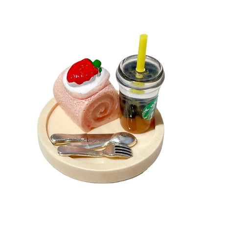 Miniature dessert roll with strawberry topping and iced drink on a plate, perfect for dollhouse or photography props.