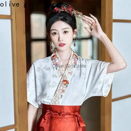 Traditional Hanfu oversized embroidered blouse worn by a woman, featuring floral designs and a satin skirt.