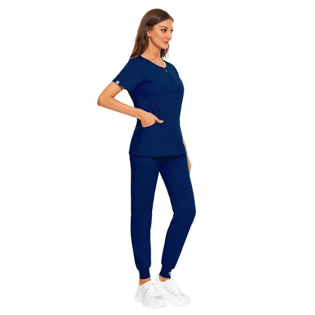 Women wearing navy blue 7-color nursing work uniform with zipper V-neck top and matching pants, ideal for beauty salons and kitchens.