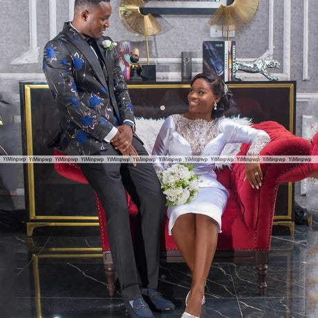 Couple in elegant attire, groom in floral jacket and bride in tea-length satin gown, celebrating their wedding moments.