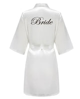 Elegant white satin robe with 'Bride' written in cursive, perfect for bridal occasions and wedding preparations.