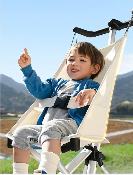 Smiling child in a lightweight travel stroller, showcasing comfort and style outdoors with a scenic backdrop.