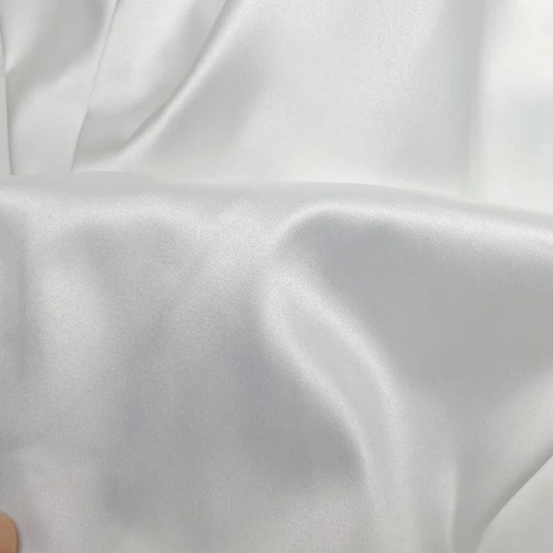 Close-up of smooth, luxurious white satin fabric ideal for wedding dresses.