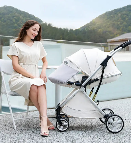 Woman sitting beside a foldable twin baby stroller outdoors with mountains in the background.