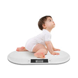 Ergonomic digital baby scale with a toddler crawling on it, showing weight measurement.