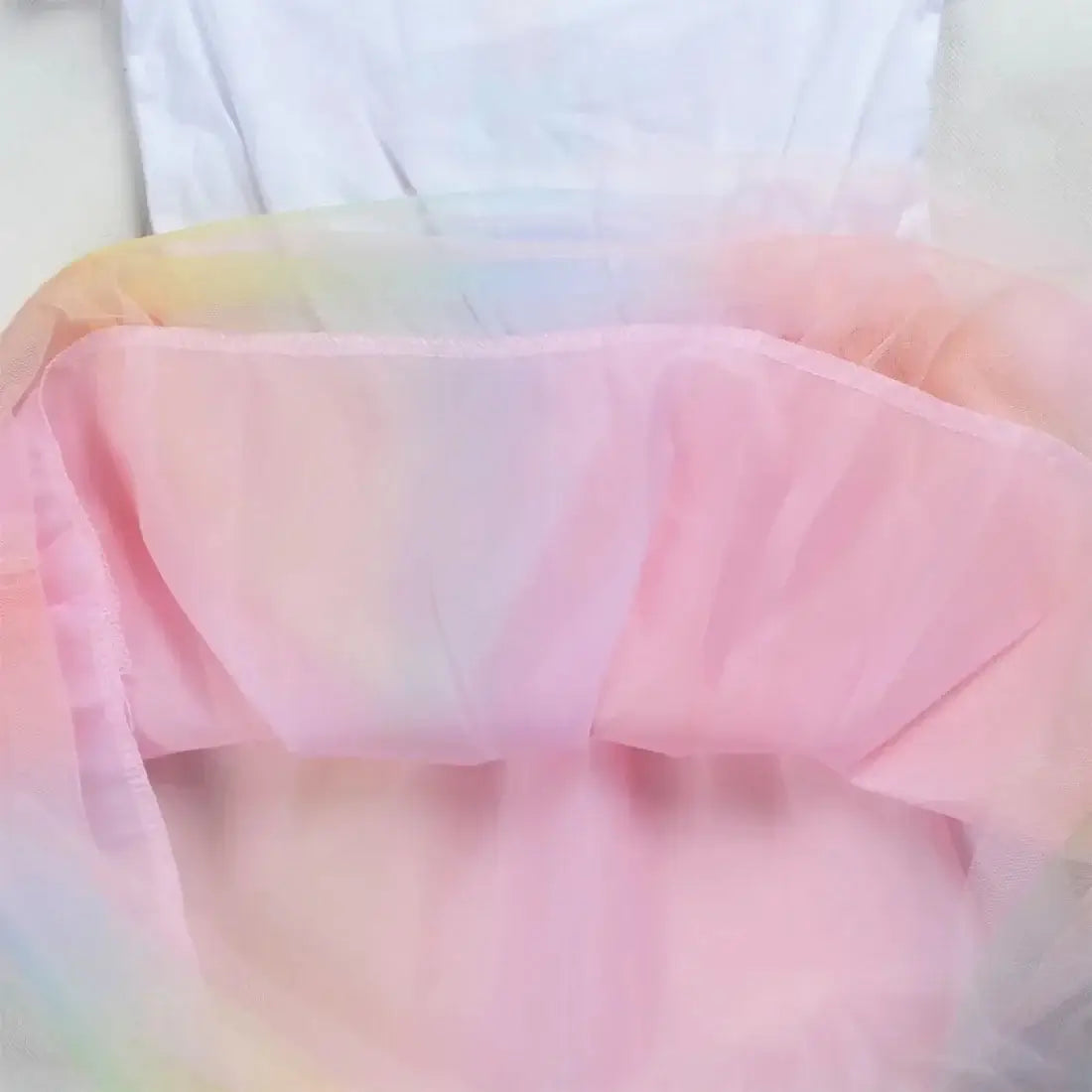Inside view of a baby girls' dress featuring colorful mesh layers, designed for summer wear.