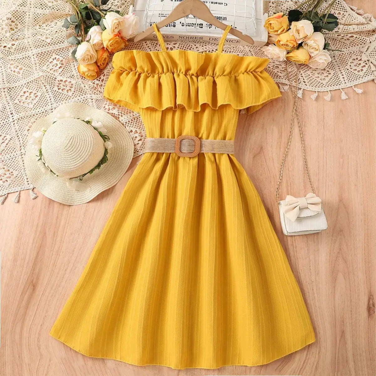 Girls yellow casual dress with off-shoulder ruffle, belt, and summer accessories like a hat and bag.