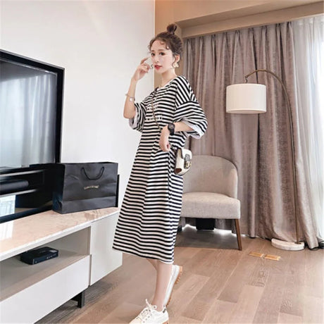Striped t-shirt maternity dress in loose fit, featuring boat neck and mid-calf length, perfect for summer wear.
