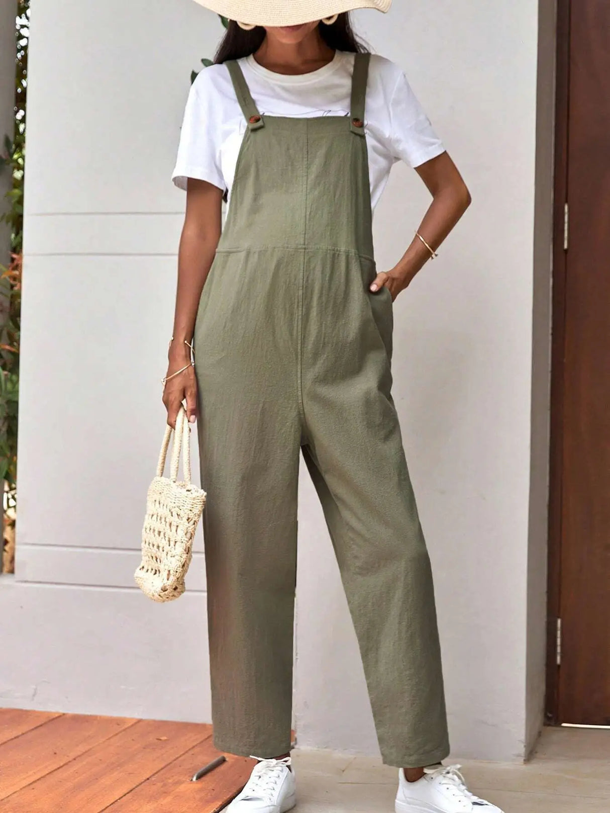 Stylish adjustable maternity overalls in olive green, paired with a white tee and a casual bag, perfect for comfort.
