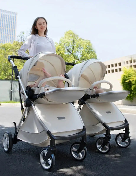 Twin baby stroller with two seats, designed for infants, showcasing a modern style outdoors.