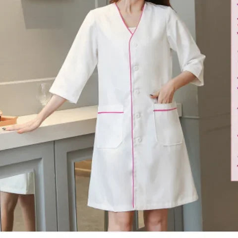 White short sleeve lab coat for women, featuring pink trim and pockets, ideal for salons and medical use.