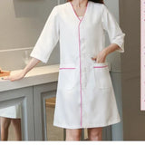 White short sleeve lab coat for women, featuring pink trim and pockets, ideal for salons and medical use.