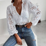Elegant white lace blouse with V-neck and long sleeves, styled with blue jeans and a belt for summer fashion.