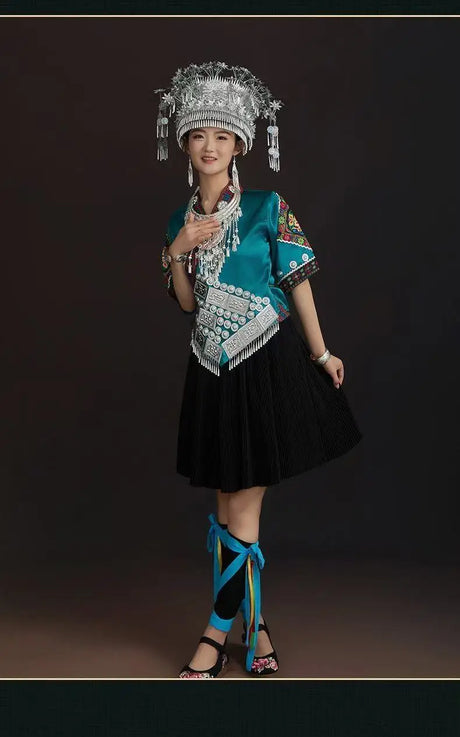 Woman in vibrant Miao embroidery suit with traditional accessories, styled for festival celebrations.