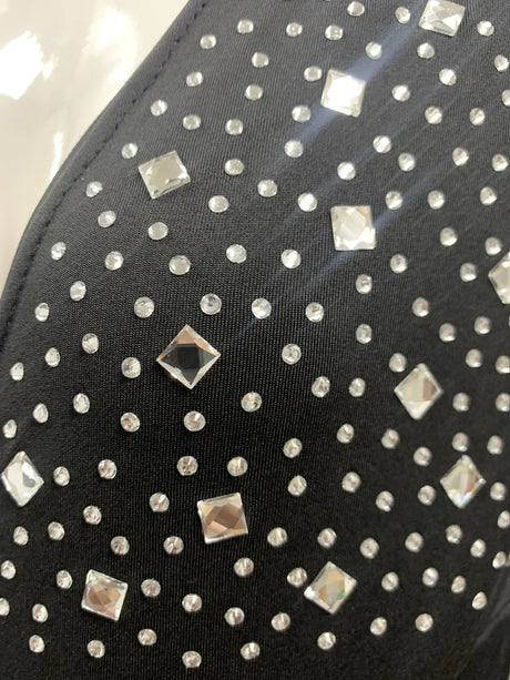 Close-up of shiny rhinestones and studs on black fabric, adding elegance to the maternity dress for summer events.
