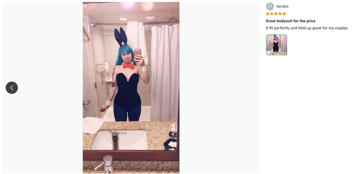 Woman in a strapless bodysuit with bunny ears and blue hair in a bathroom mirror selfie.