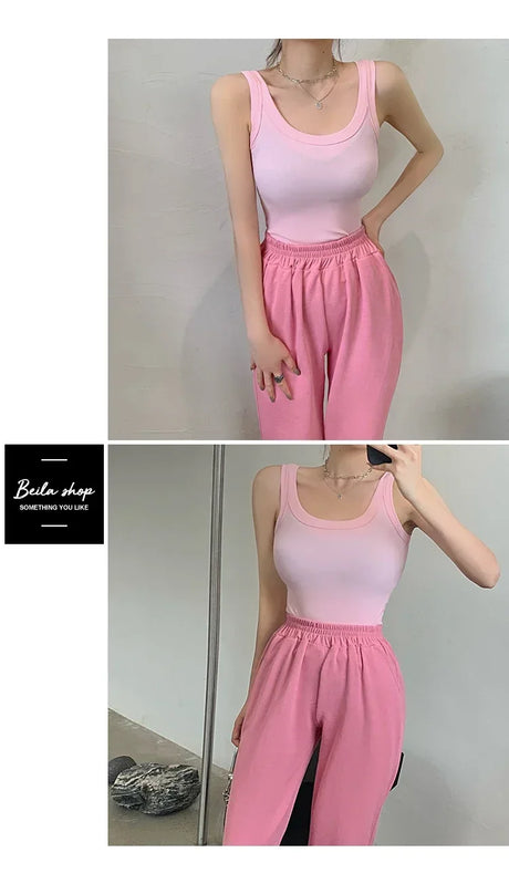 Model wearing a pink sleeveless ribbed tank top paired with pink sweatpants, showcasing a casual streetwear look.