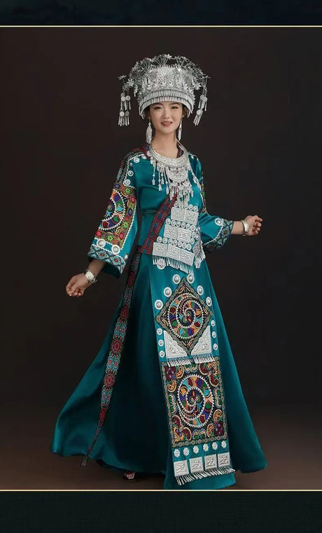 Woman wearing a Miao embroidery suit, showcasing colorful patterns and traditional accessories in a elegant pose.