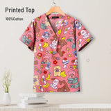 Cute printed pediatric nursing scrub top in pink, 100% cotton, featuring playful designs for healthcare professionals.