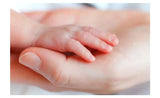 A close-up of a newborn baby's hand resting in an adult hand, symbolizing care and tenderness.
