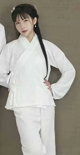 Young woman wearing a traditional white Hanfu outfit, showcasing elegant embroidery and a modern design.
