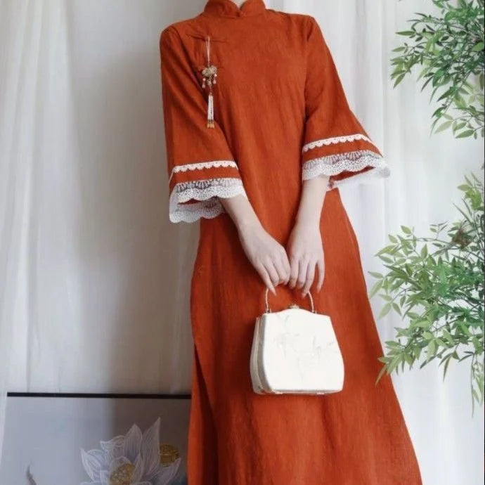 Girl wearing an orange Cotton Jacquard Cheongsam Qipao Dress with lace trim, holding a small white bag.