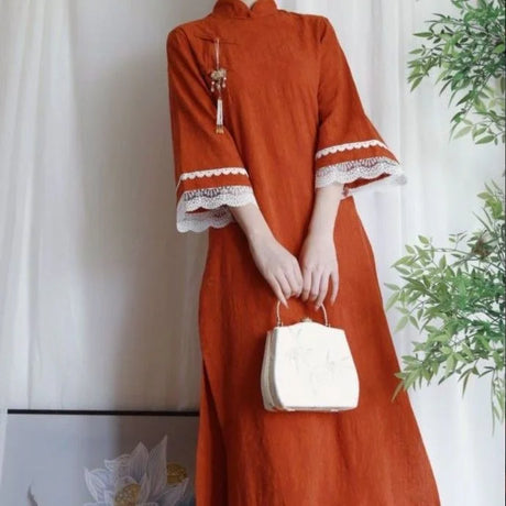 Girl wearing an orange Cotton Jacquard Cheongsam Qipao Dress with lace trim, holding a small white bag.