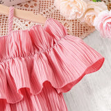 Pink girls casual dress with one-line shoulder strap and ruffled neckline detail on a wooden hanger.