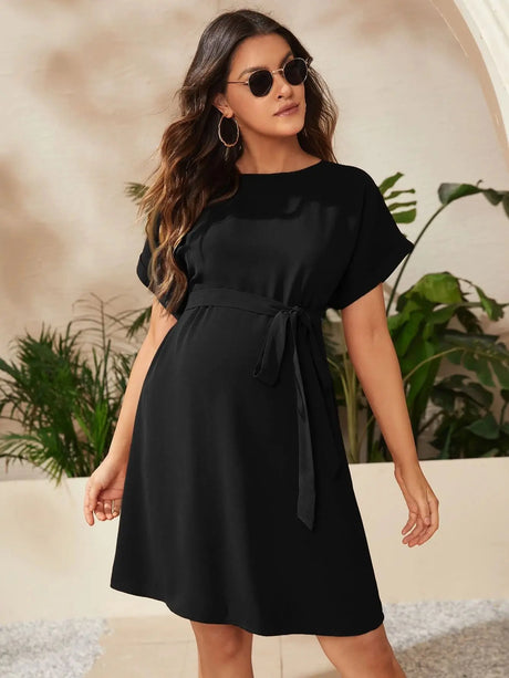 Elegant bat-sleeve maternity tunic in black, perfect for summer photoshoots, featuring a stylish tie waist.