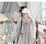 Woman in a vintage Chinese Hanfu dress holding a decorative fan, showcasing traditional elegance with floral decor in background.