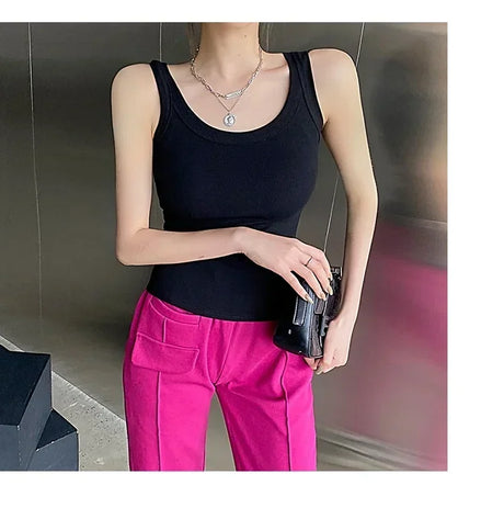 Stylish woman wearing a black RetroRib™ 90s vintage ribbed tank top with pink pants, perfect for streetwear fashion.