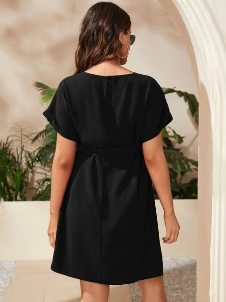 Back view of a black bat-sleeve maternity tunic dress, showcasing elegant design and knee-length fit.