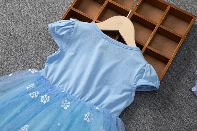 Girls summer flying sleeve dress featuring a light blue top with puff sleeves and a knee-length tulle skirt adorned with snowflakes.