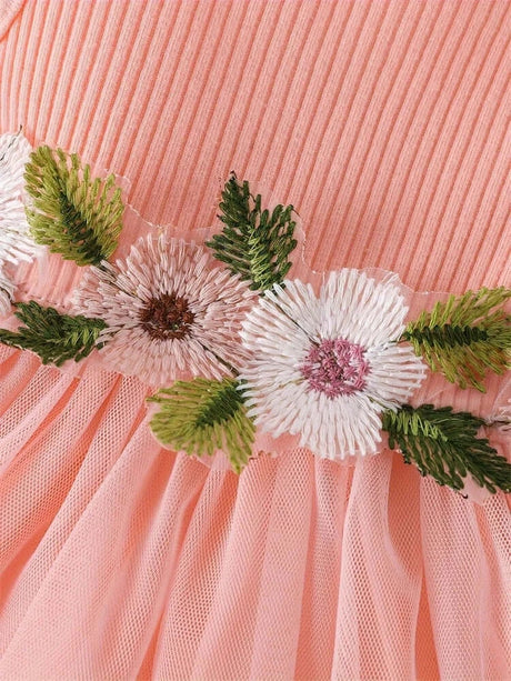 Close-up of peach dress for baby girls, featuring floral embroidery and delicate lace details ideal for summer.