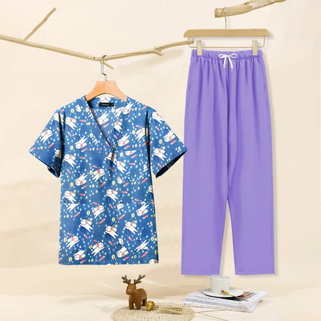 Cartoon print dental scrubs featuring a blue top with rocket designs and purple pants, ideal for pet grooming workwear.